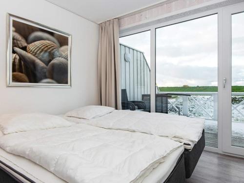 a bedroom with a bed and a large window at Two-Bedroom Holiday home in Wendtorf 5 in Wendtorf