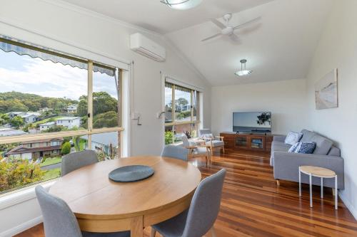 a living room with a table and chairs and a tv at 36 Churchill in Forster