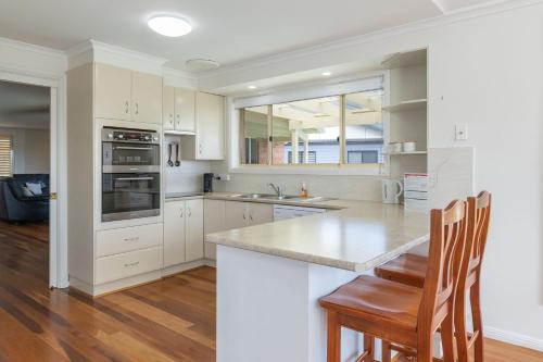 a kitchen with white cabinets and a counter top at 36 Churchill in Forster