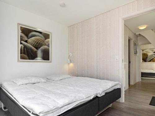 Bett in einem Zimmer mit einem Bild an der Wand in der Unterkunft Two-Bedroom Holiday home in Wendtorf 17 in Wendtorf