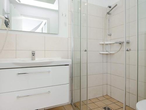 y baño con ducha, lavabo y espejo. en Two-Bedroom Holiday home in Wendtorf 19, en Wendtorf