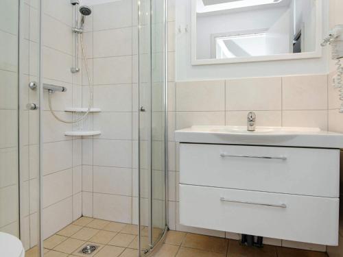 a bathroom with a shower and a sink and a mirror at Holiday Home Strandblick in Wendtorf