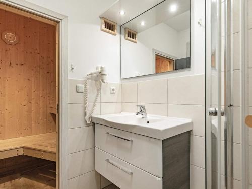 a white bathroom with a sink and a mirror at Two-Bedroom Holiday home in Wendtorf 20 in Wendtorf