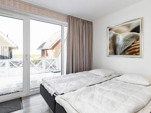 a bedroom with a bed and a large window at Two-Bedroom Holiday home in Wendtorf 20 in Wendtorf
