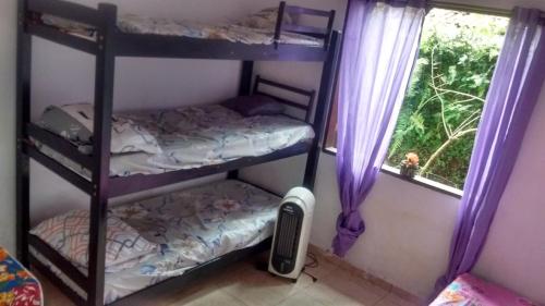 twee stapelbedden in een kamer met een raam bij Casa Caiçara de Hospedagem Paraty in Paraty
