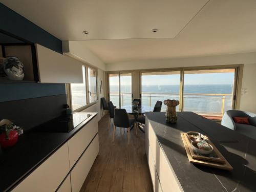 - une cuisine avec une table et une vue sur l'océan dans l'établissement Appartement 3* face plage avec balcon et 2 salles d'eau - FR-1-197-551, à Les Sables-dʼOlonne
