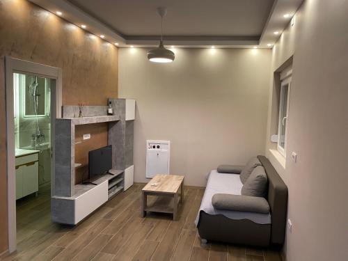 a living room with a bed and a tv and a table at King Milans Apartment in Belgrade