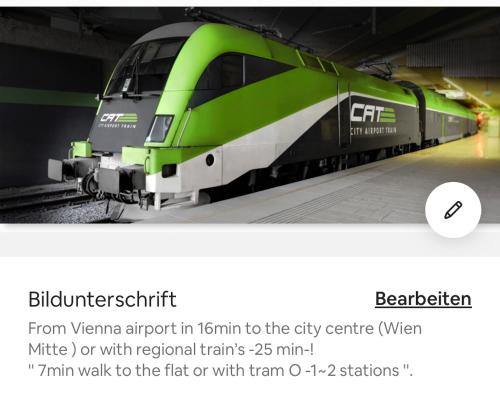 a green train is parked at a train station at Klimatisierte Sehr Zentrale Wohnung-Loftstyle- in Vienna