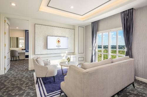 a living room with a couch and a table and chairs at Eastin Hotel Vientiane in Vientiane