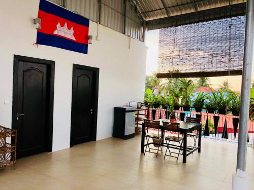 シェムリアップにあるソファット ヴィラのテーブルと椅子と旗のある部屋