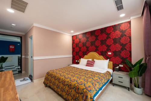 a bedroom with a bed and a red wall at 波西塔諾villa民宿 全新旅店市中心 歐式別墅 親子住宿 in Xiaoliuqiu