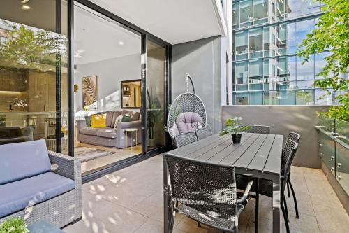 布里斯本的住宿－Southbank Heart+2 Bed+Balcony+Pool+Gym+Free Wifi，天井配有桌椅和沙发。