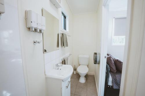 a white bathroom with a toilet and a sink at BIG4 Breeze Holiday Parks - Carnarvon Gorge in Carnarvon Gorge