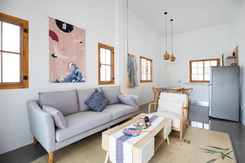 a living room with a couch and a table at Villa Sunrise Garden A181 in Thalang