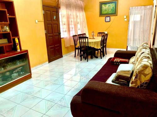 a living room with a couch and a table at Ramizu Homestay Pokok Sena in Pokok Sena