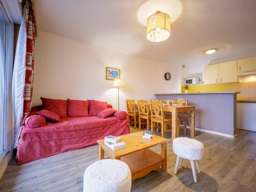 un salon avec un canapé rouge et une table dans l'établissement Appartement 8 personnes, Wi-Fi, parking - Peyragudes - FR-1-695-15, à Germ
