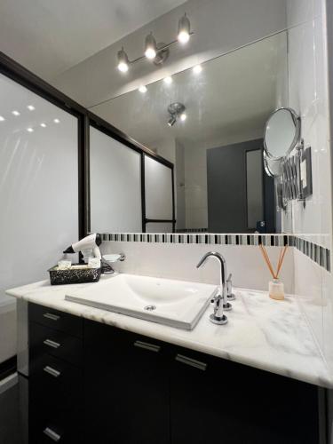 een badkamer met een wastafel en een grote spiegel bij Locación Jujuy in San Salvador de Jujuy