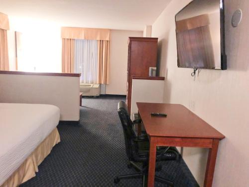a hotel room with a desk and a bed at Days Inn by Wyndham Niagara Falls Centre St By the Falls in Niagara Falls
