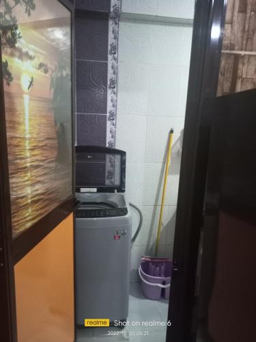 eine Mikrowelle auf einem Kühlschrank im Zimmer in der Unterkunft Cash and cash only please in ‘Izbat al Qaşr