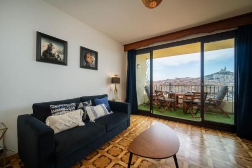 un salon avec un canapé et une grande fenêtre dans l'établissement Terrace Apartment Old Port Exceptional View, à Marseille