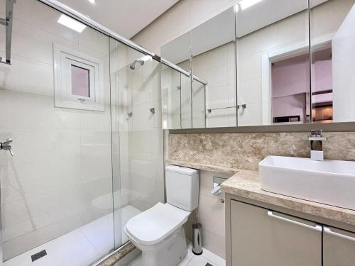y baño con aseo, lavabo y ducha. en Apartamentos Loft One no CENTRO by Achei Gramado, en Gramado