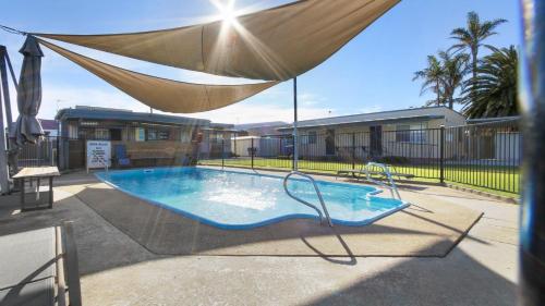 a large swimming pool with a hammock over it at Ocean Bridge Lakes Entrance in Lakes Entrance