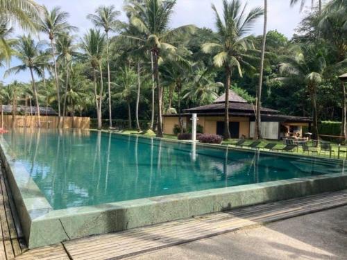 ein Swimmingpool vor einem Resort mit Palmen in der Unterkunft Siam Royal View Private Pool Villa by PSR in Ko Chang