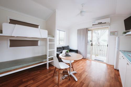 a living room with a table and a kitchen at Discovery Parks - Bargara in Bargara