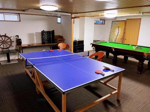 a room with a ping pong table and pool tables at Hakuba Sun Valley Hotel in Hakuba