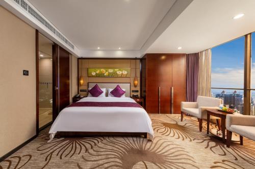 a bedroom with a large bed and a large window at Guangdong Hotel (Zhuhai) in Zhuhai