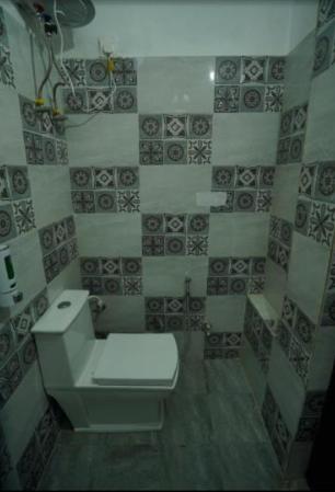 ダノルティにあるSpandan Villasのトイレとタイル張りの壁があるバスルーム