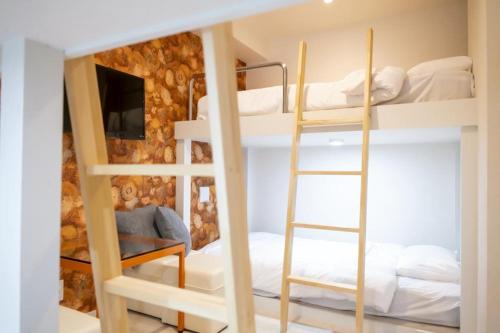 a room with two bunk beds and a television at GRAND CAVE MOTOMACHI in Yokohama