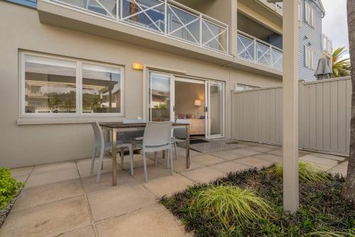 a patio with a table and chairs in front of a house at Crow's Nest Apartments in Whitianga