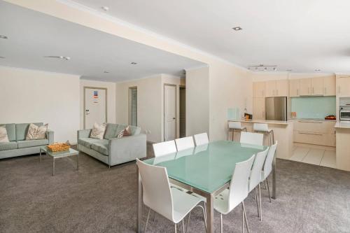 a living room with a table and chairs and a kitchen at Crow's Nest Apartments in Whitianga