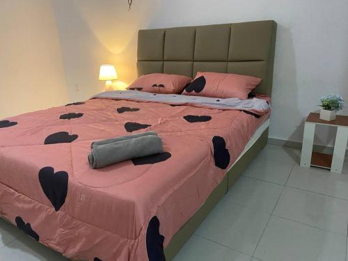 a bedroom with a large bed with pink sheets and pillows at Islamic Homestay Promenade Tanjung Lumpur in Kuantan