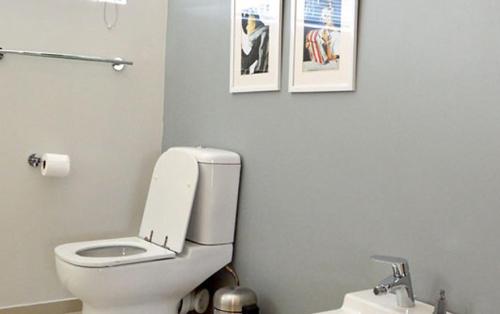 a bathroom with a toilet and two pictures on the wall at THE WHITE HOUSE in Johannesburg