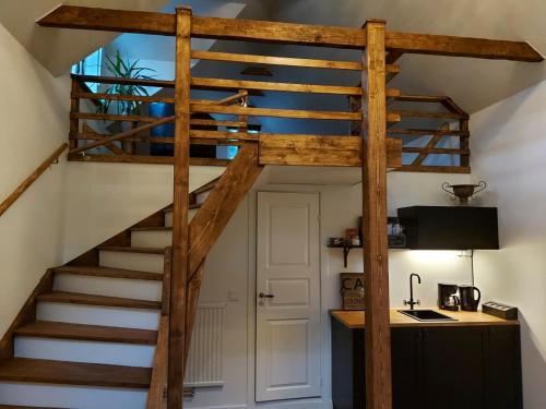 a loft bed with a staircase in a room at Gårdshus med spabad utomhus in Vadstena