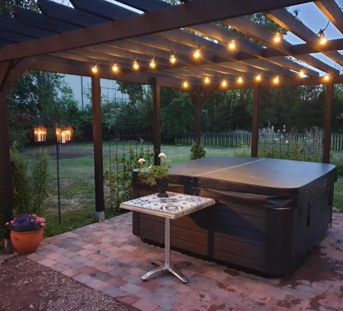 a pool table under a pergola with lights at Gårdshus med spabad utomhus in Vadstena