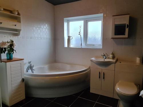 ein Badezimmer mit einer Badewanne, einem Waschbecken und einem WC in der Unterkunft Spacious, 5 bed house for 9 in Chester in Chester