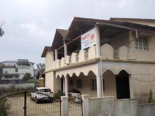 a building with a sign on the side of it at Prashanth Family Homestay in Madikeri