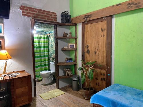 a bedroom with a toilet and a green wall at Casa San Pablo B & B in San Pablo