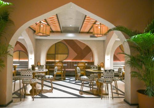 Bur'Dera - a Boutique Luxury Hotel في جايبور: مطعم فيه طاولات وكراسي في الغرفة