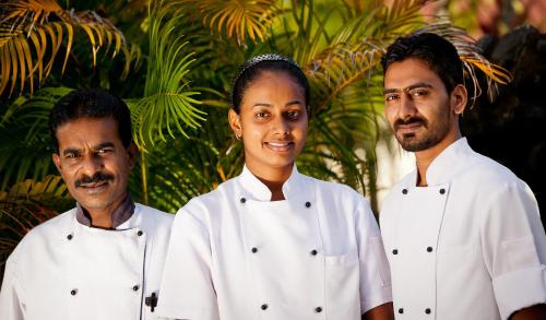 un gruppo di tre chef che si trovano uno accanto all'altro di Gecko's Resort a Sigatoka
