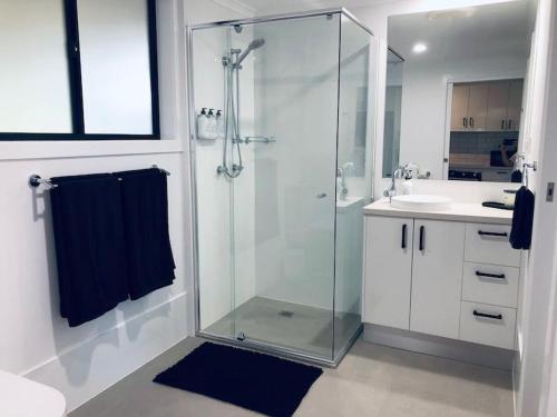 uma casa de banho com uma cabina de duche em vidro e um lavatório. em Selah Valley Estate em Limpinwood