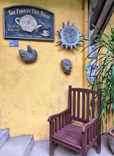 a wooden bench sitting in front of a wall with a sign at Casa San Pablo B & B in San Pablo