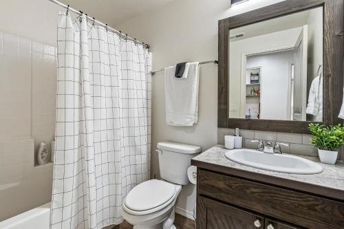 a bathroom with a toilet and a sink and a mirror at Urban Boho Caldwell 3 Bedroom Great for Families! in Caldwell