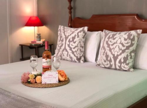 a tray with a bottle of wine and two glasses on a bed at Casa San Pablo B & B in San Pablo