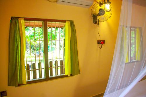 a window with green curtains in a room at Machcha Lodge Sigiriya in Sigiriya