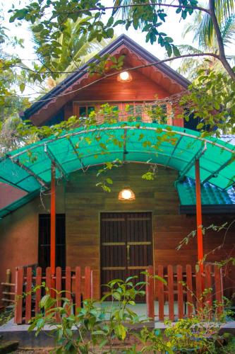 a small house with a blue roof and a fence at Machcha Lodge Sigiriya in Sigiriya