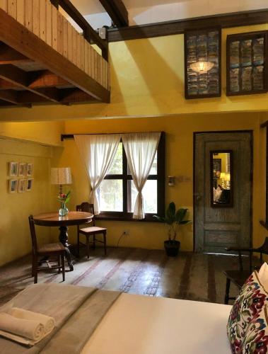 a room with a bed and a table and windows at Casa San Pablo B & B in San Pablo